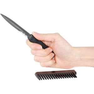 Black comb knife open in hand